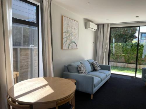ウェリントンにあるExecutive Townhouse in Island Bay with Free Parkingの青いソファとテーブルのあるリビングルーム