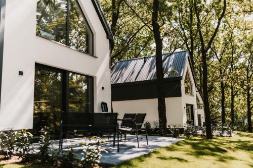 a house with a conservatory and a table and chairs at Treehouses in Skorochów