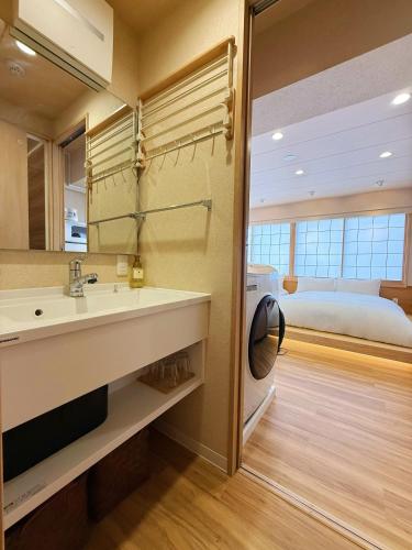 a bathroom with a sink and a bed in a room at Rakuyu asakusa in Tokyo