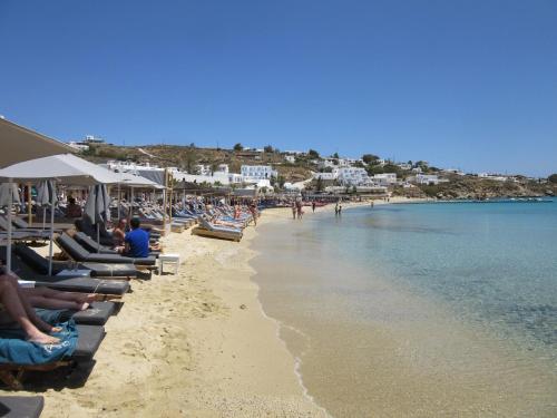 a beach filled with lots of boats on a sunny day at Acrogiali Beach Hotel Mykonos in Platis Gialos