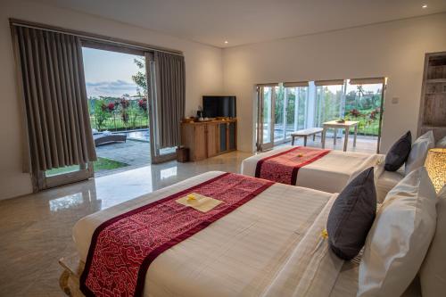 a hotel room with two beds and a balcony at Kayun Retreat Mas Suite in Ubud