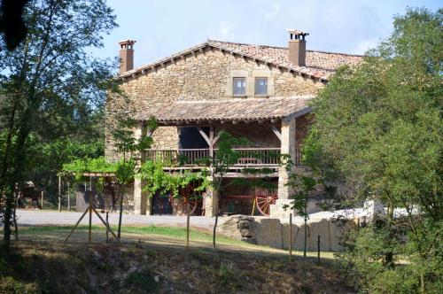 una antigua casa de piedra con un balcón frente a ella en Mas Sabaters - L'Era de Sabaters, en Tavernoles