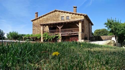 an old brick house with a balcony in a field at Mas Sabaters - L'Era de Sabaters in Tavernoles