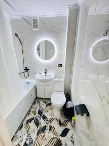 a bathroom with a toilet and a tub and a sink at Биржан Сал центр 2 к in Taldykorgan