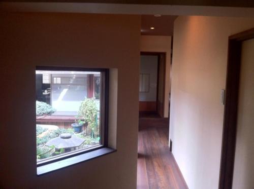 a view of a hallway with a window in a house at Tobaya Ryokan in Hikone