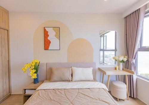 a bedroom with a bed and a table with flowers at The Song Your House Apartment - Căn Hộ Du Lịch Biển Vũng Tàu in Vung Tau
