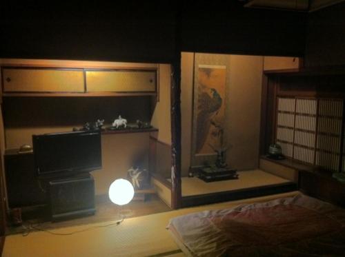 a room with a bed and a television in a room at Tobaya Ryokan in Hikone