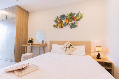 a bedroom with a white bed with areath on the wall at The Song Your House Apartment - Căn Hộ Du Lịch Biển Vũng Tàu in Vung Tau