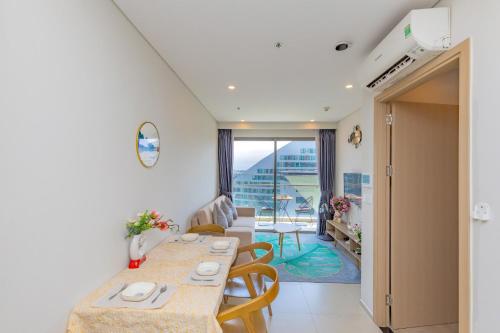 a room with a table and chairs and a balcony at The Song Your House Apartment - Căn Hộ Du Lịch Biển Vũng Tàu in Vung Tau