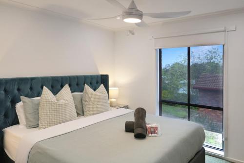 a bedroom with a large bed with a large window at Spa Haus Belmont- 2 King beds, Spa, Pets Welcome, Beaches, Golf, Shopping, Geelong in Belmont