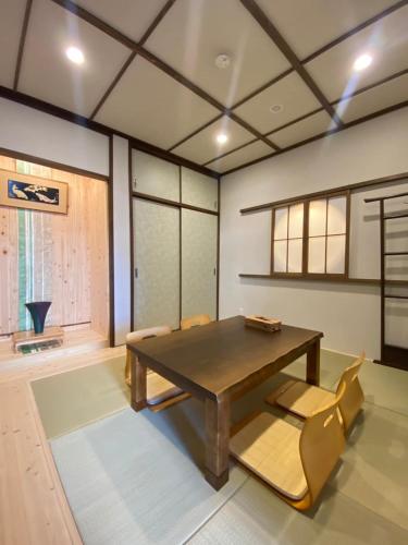 a dining room with a wooden table and chairs at Suzuan 鈴庵 in Takamatsu