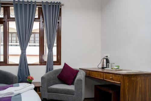 una camera con una scrivania, due sedie e un letto di Hotel Zi a Gangtok