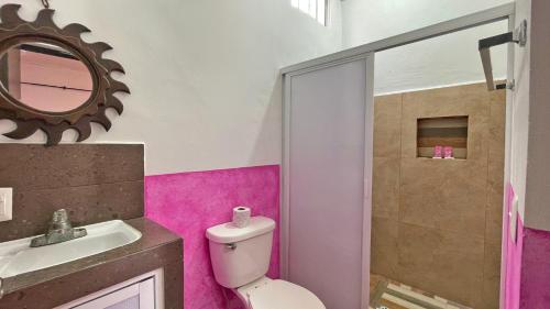 a bathroom with a toilet and a sink and a mirror at Maya Dreams Bacalar in Bacalar