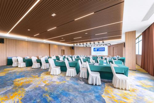 a conference room with a long table and white chairs at Holiday Inn Express Suzhou City Center by IHG in Suzhou