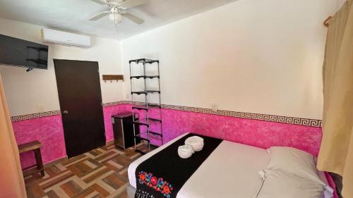 a bedroom with a pink accent wall and a bed at Maya Dreams Bacalar in Bacalar