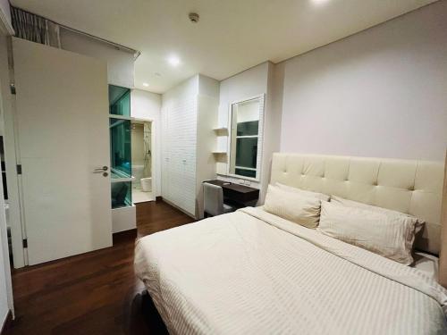 Un dormitorio con una gran cama blanca y una ventana. en Thong Lor Luxury condo with Swimming Pool, Fast Wifi, en Sathani Khlong Tan