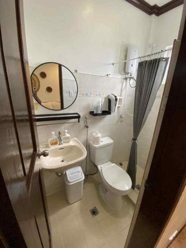 a small bathroom with a toilet and a sink at Oceana Bay Coron in Coron