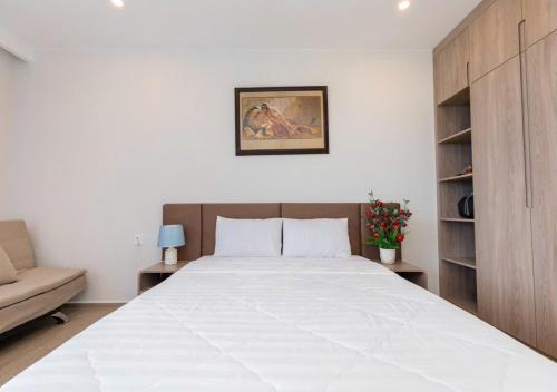 a bedroom with a large bed and a couch at The Song Your House Apartment - Căn Hộ Du Lịch Biển Vũng Tàu in Vung Tau