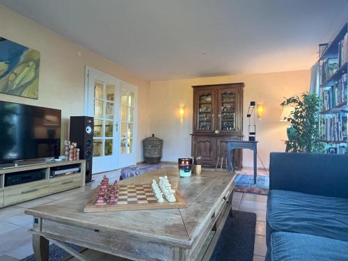 a living room with a table with a chess game on it at Maison de charme avec jacuzzi location 1 ou 2 semaines début juillet 2026 in Preverenges