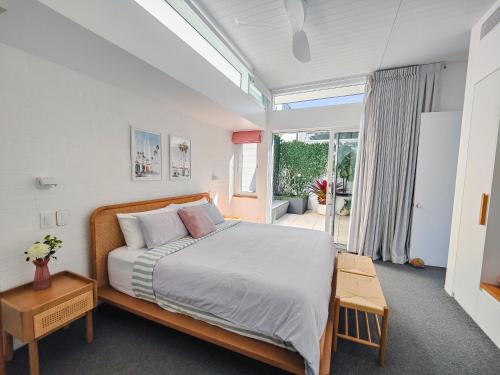 a bedroom with a large bed and a large window at Pool House, luxury 2 bedroom with ocean views, pool and sauna in Lennox Head