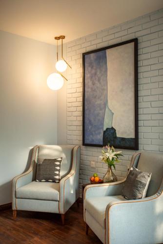 a living room with two chairs and a painting at La Viola, 3BHK Villa with rooftop Jacuzzi, close to Anjuna & Vagator Beach with Private Pool, Kitchen, Terrace in Anjuna