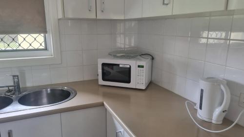 a kitchen with a sink and a microwave on a counter at KS Maryborough 2-Bedroom Apartment in Maryborough