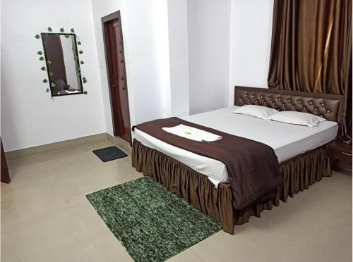 a bedroom with a bed with a mirror and a rug at Nirvis Grand in Guwahati