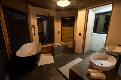 a bathroom with two sinks and a tub and a toilet at Sasi Africa Luxury Tented Bush Lodge in Bergville