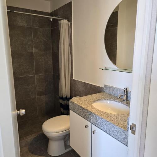 a bathroom with a toilet and a sink and a mirror at Departamento Arequipa- PERUMIN 2025 in Paucarpata