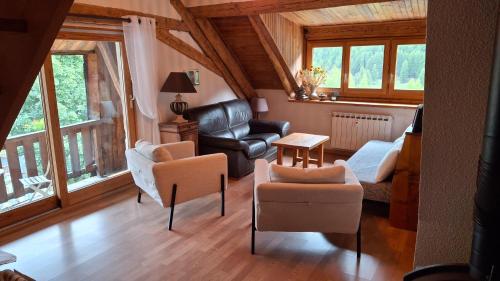 a living room with a couch and a chair at Gîte à Molines en Queyras 8-15 pers in Molines-en-Queyras
