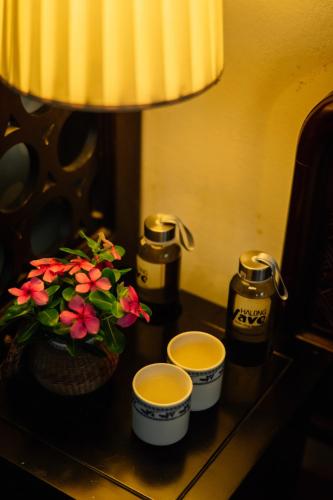 a table with two cups and flowers on it at Viet House Yen Duc Village in Tử Lạc