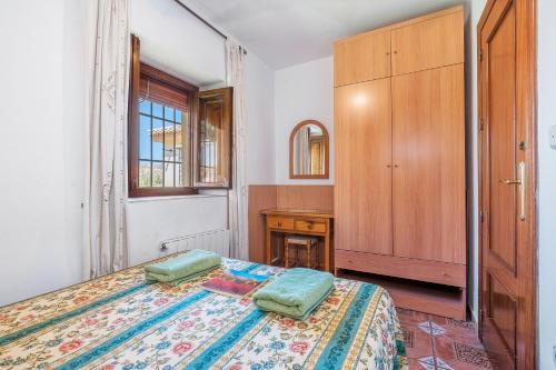 a bedroom with a bed and a wooden cabinet at Casa Roque in Monachil