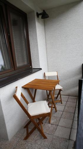 two chairs and a wooden table and chairs next to a window at Apartments Pod Kotlom in Vysoké Tatry