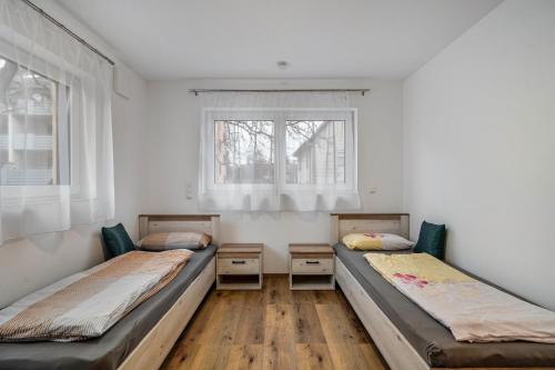 two beds in a room with two windows at City Villa Bad Dürrheim Oberge in Bad Dürrheim