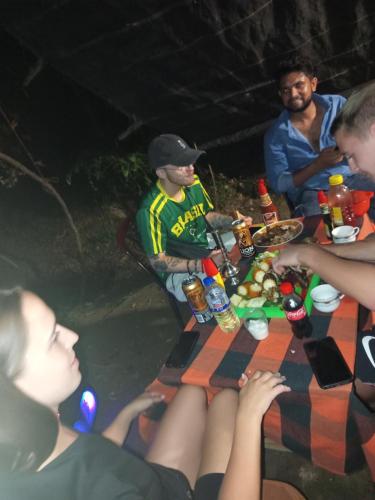 a group of people sitting around a picnic table at Sigiri Hunter's Eco Tree lodge in Sigiriya