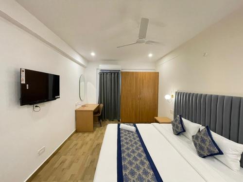 a bedroom with a bed and a flat screen tv at Novara Hotel Madhapur in Hyderabad