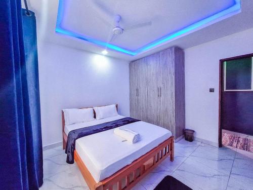 a bedroom with a bed and a blue light at Modhire in Mombasa