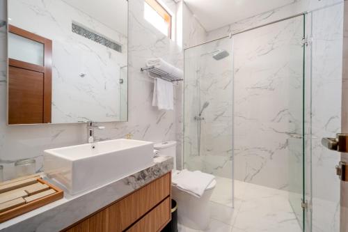 a white bathroom with a sink and a shower at Aventus Beach Grandé Villa Gianyar in Ketewel