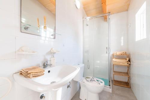 a white bathroom with a sink and a toilet at La Casa Di Ines in Porto Cristo
