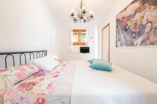 a bedroom with a bed and a painting on the wall at La Casa Di Ines in Porto Cristo
