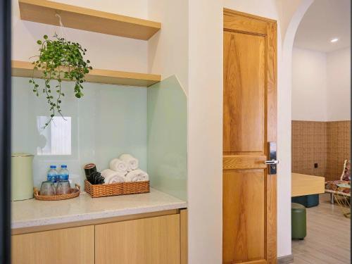 a kitchen with a counter with towels and a door at Andi Homestay-Vinhomes Grand Park in Gò Công