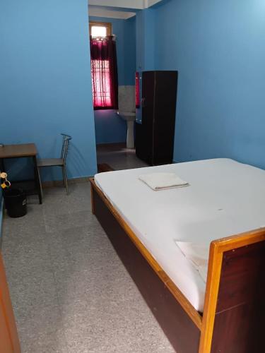 a bedroom with a bed in a blue room at Garam Masala Residency in Guwahati