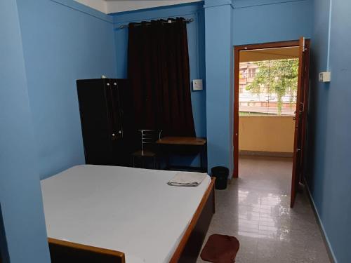 a bedroom with a bed and a blue wall at Garam Masala Residency in Guwahati