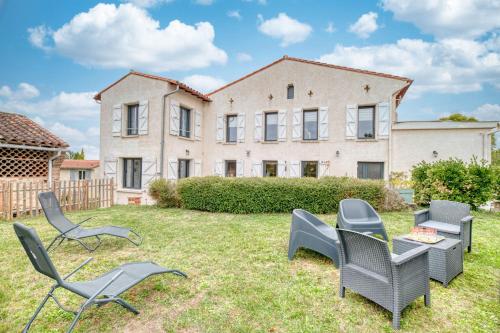 a yard with chairs and a table in front of a building at Les Echaunes in Caraman