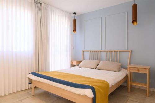 a bedroom with a bed with a yellow blanket on it at זוהר על הים - ווילה ו-3 חדרי סטודיו מהממים עם בריכה בנווה זוהר in Neve Zohar