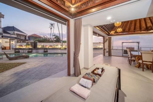 a living room with a bed and a pool at Aventus Beach Grandé Villa Gianyar in Ketewel