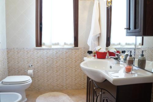 ein Bad mit einem Waschbecken und einem WC in der Unterkunft Casa Vacanza da Rosa in Custonaci