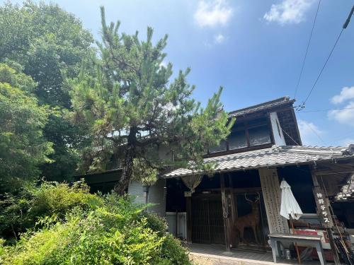 a house with a dog standing outside of it at kamino Terrace, a Japanese history and nature experience accommodation in Wakakuri