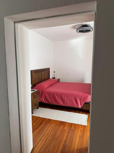 a bedroom with a red bed in a white room at casa vacanza l'Oleandro in Poggiridenti