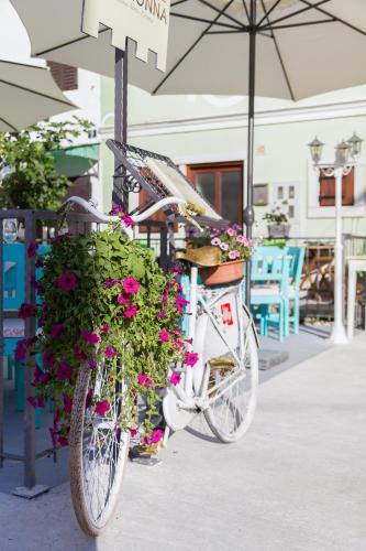 a bike with flowers on it parked on a sidewalk at Heritage Hotel Chersin in Fažana
